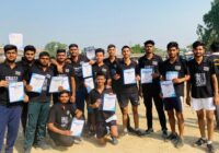 Group of Ground Zero Institute cadets holding certificates after a marathon event, posing outdoors on a sports field.