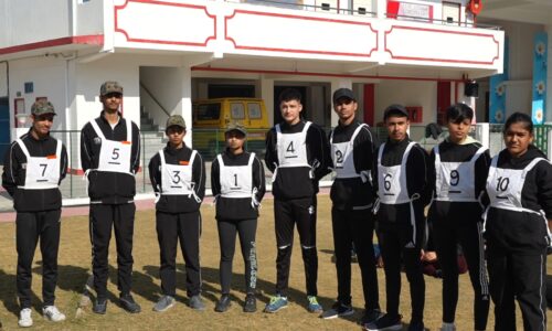 Ground Zero Institute cadets in numbered vests posing outdoors on a sports field with a building in the background.