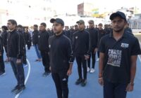 A group of young people in athletic wear standing in formation on a sports court.